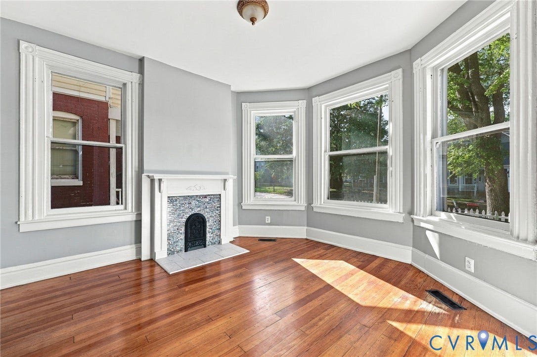 1911 3rd Avenue, Richmond, VA 23222 Hardwood flooring, fireplace with decorative surround and mantle, and bay window configuration with multi-pane windows and traditional millwork trim