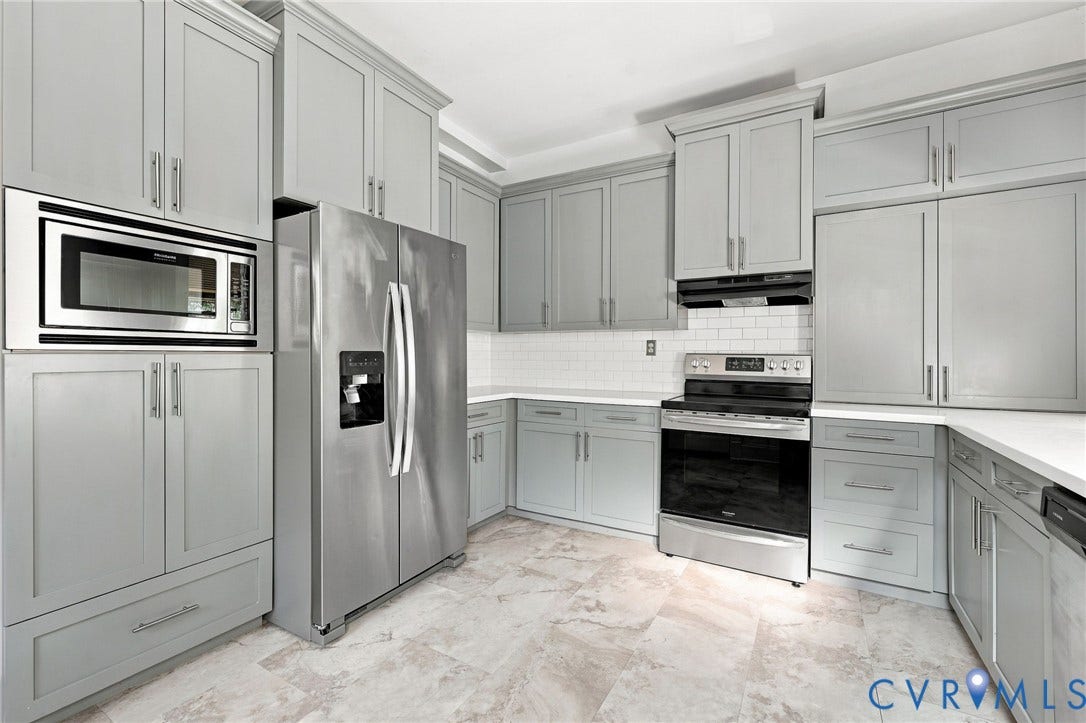 1911 3rd Avenue, Richmond, VA 23222 Kitchen featuring grey Shaker-style cabinetry, stainless steel appliances including a built-in microwave and range, white subway tile backsplash, and stone-finish tile flooring
