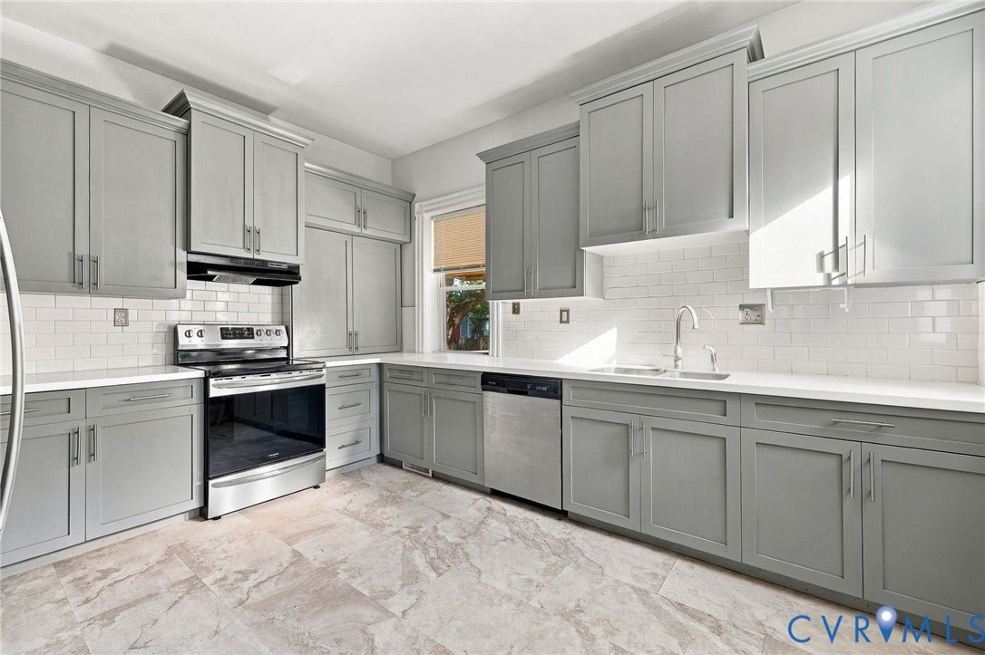 1911 3rd Avenue, Richmond, VA 23222 Kitchen featuring shaker-style cabinetry, stainless steel appliances, white subway tile backsplash, solid-surface countertops, and stone-finish flooring