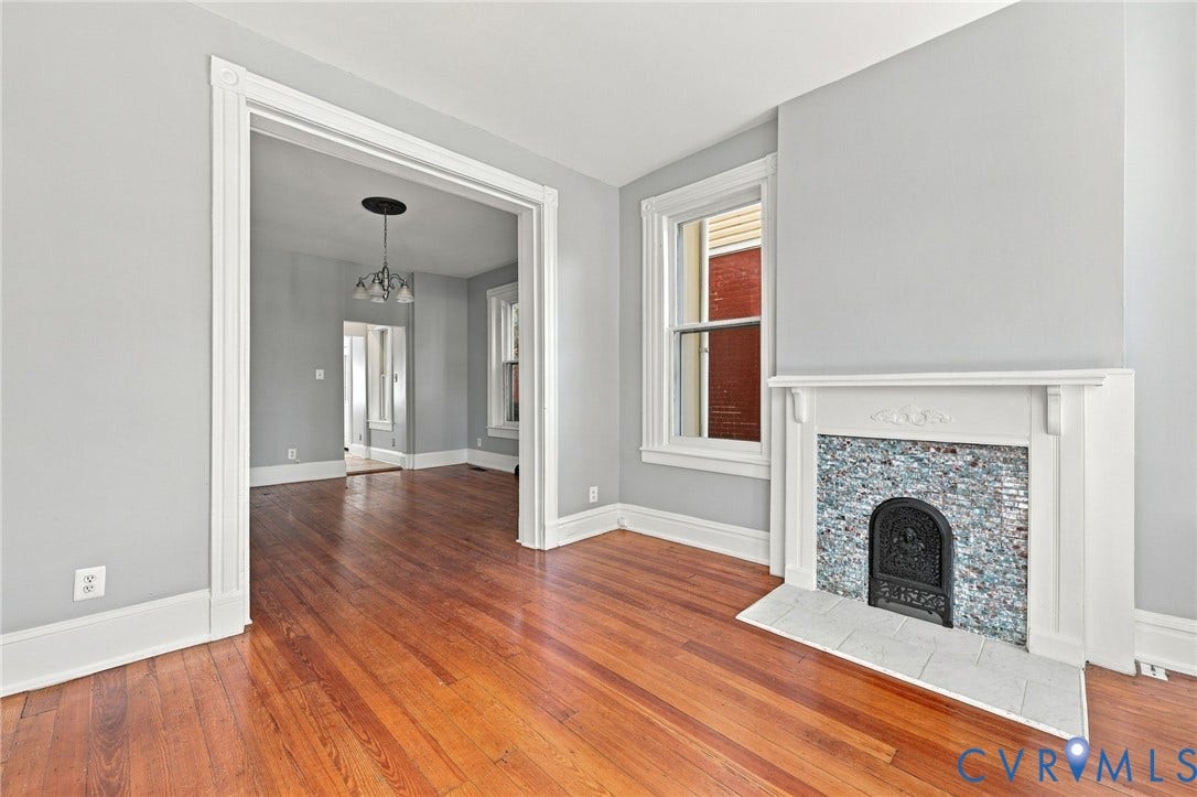1911 3rd Avenue, Richmond, VA 23222 Living area featuring wood-finish flooring, a fireplace with decorative tile surround and white mantel, and wide doorway trim