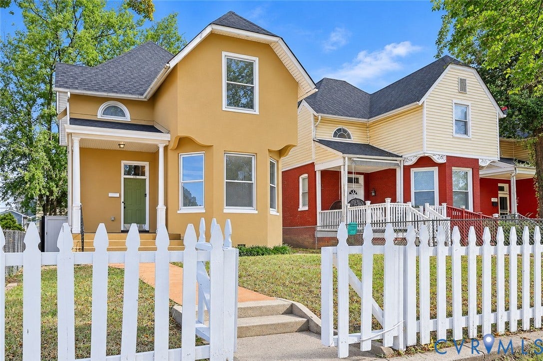 1911 3rd Avenue, Richmond, VA 23222 Multi-gabled exterior featuring lap siding and stucco finishes, covered front porches with architectural columns, and a perimeter white picket fence