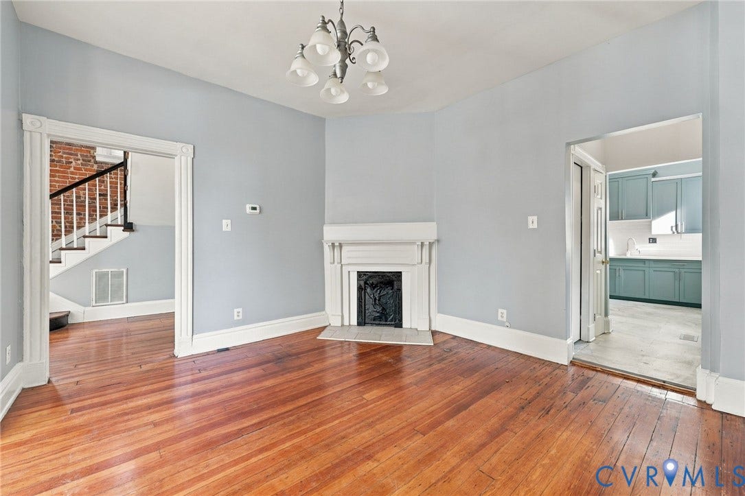 1911 3rd Avenue, Richmond, VA 23222 Wood-finish flooring, central fireplace with a classic mantel, arched five-light chandelier, and decorative door casing