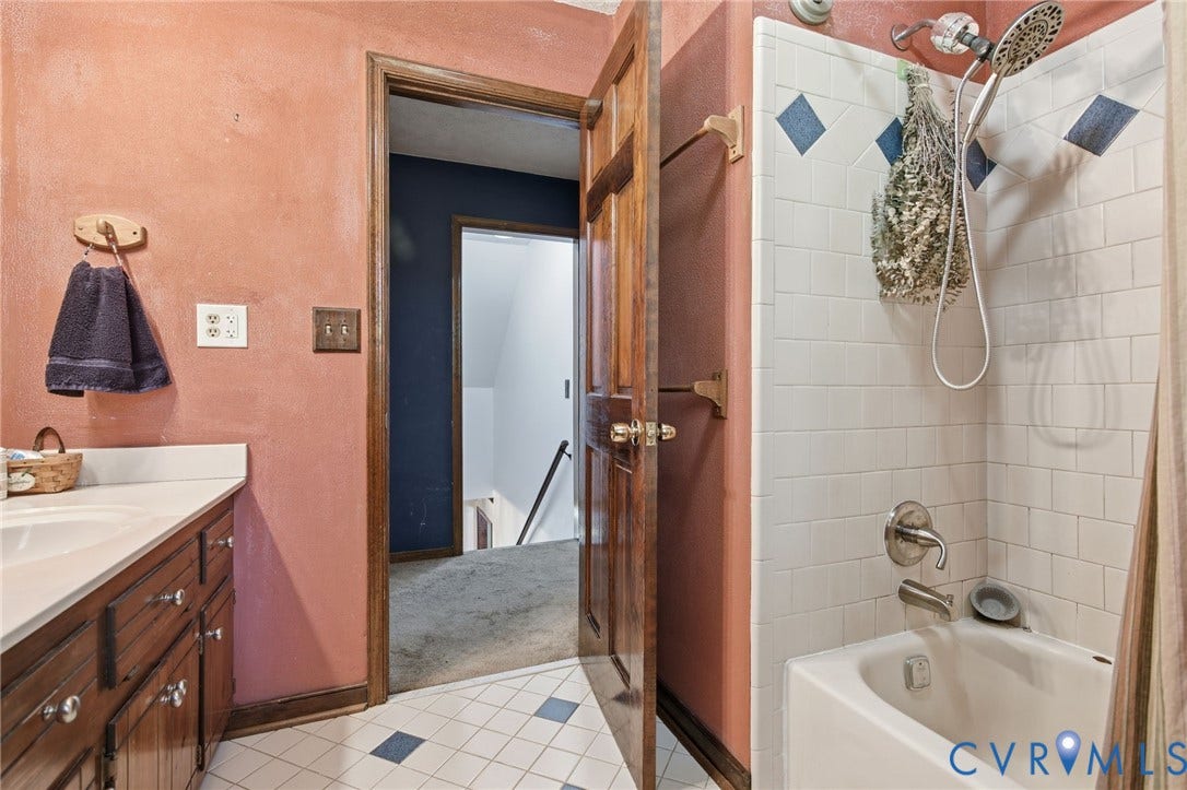 1330 Ruffin Mill Road, South Chesterfield, VA 23834 Bathroom featuring a vanity with integrated sink, white subway tile shower surround with decorative accent diamonds, porcelain tub, and wood-finish cabinetry