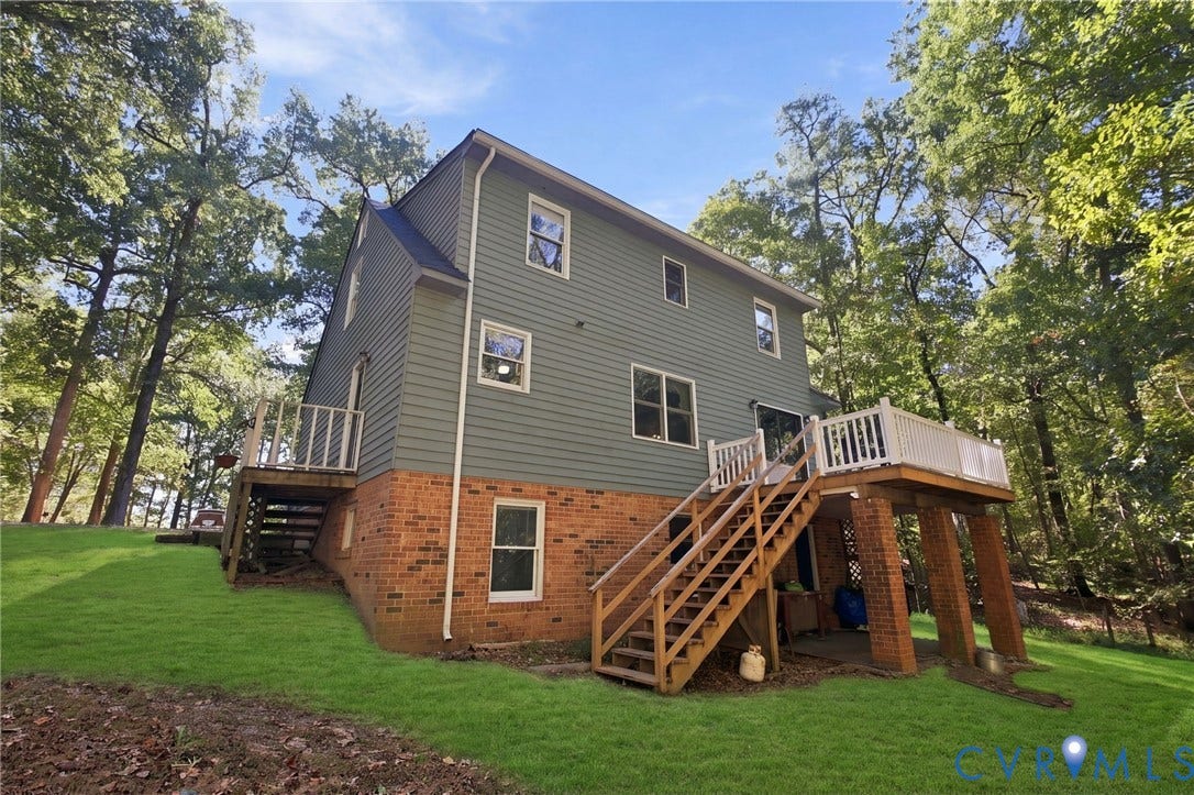 1330 Ruffin Mill Road, South Chesterfield, VA 23834 Exterior featuring horizontal siding, a brick foundation, elevated wood deck with white railings, and a wooded lot