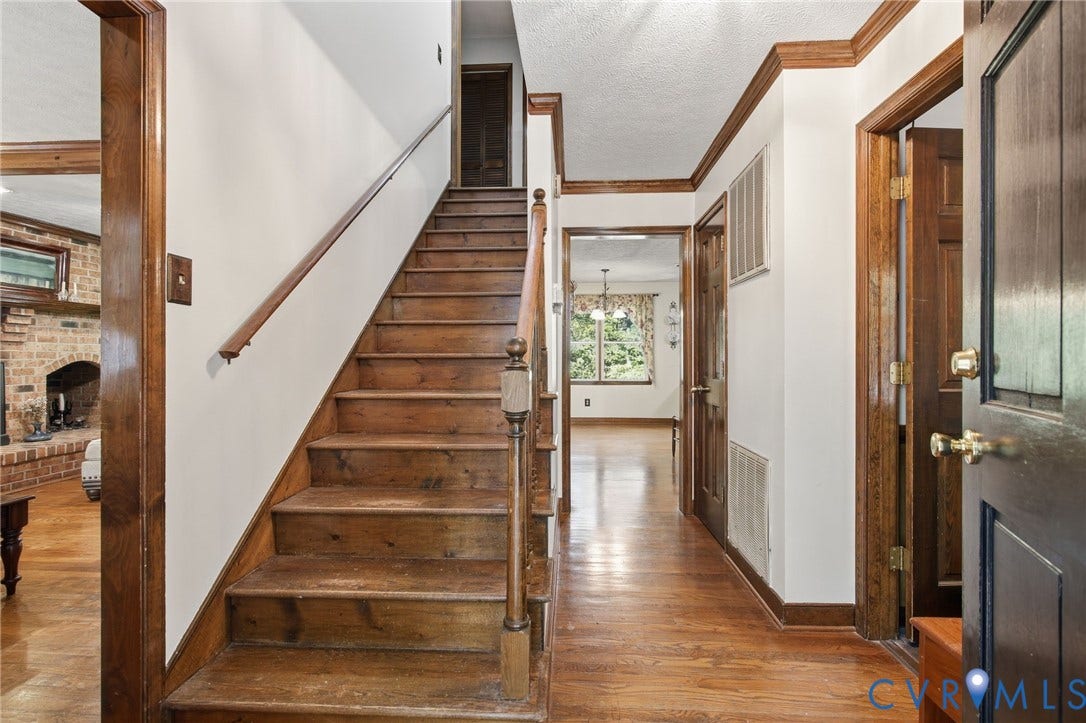 1330 Ruffin Mill Road, South Chesterfield, VA 23834 Foyer featuring wood flooring, a wood staircase with a matching handrail and baluster, crown molding, and stained wood door trim
