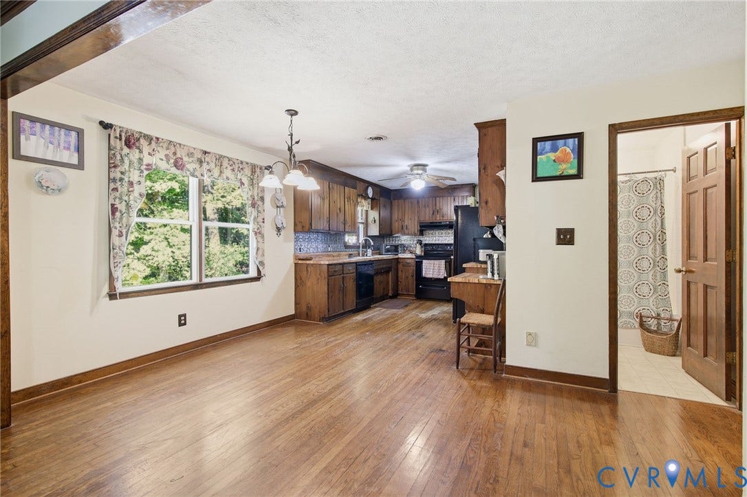 1330 Ruffin Mill Road, South Chesterfield, VA 23834 Kitchen area featuring wood cabinetry, wood flooring, a multi-light chandelier, and a six-panel wooden door