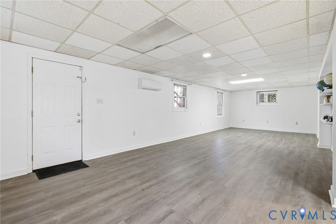1330 Ruffin Mill Road, South Chesterfield, VA 23834 Finished space featuring wood-finish flooring, a suspended ceiling, built-in shelving, a wall-mounted ductless climate control unit, and recessed lighting