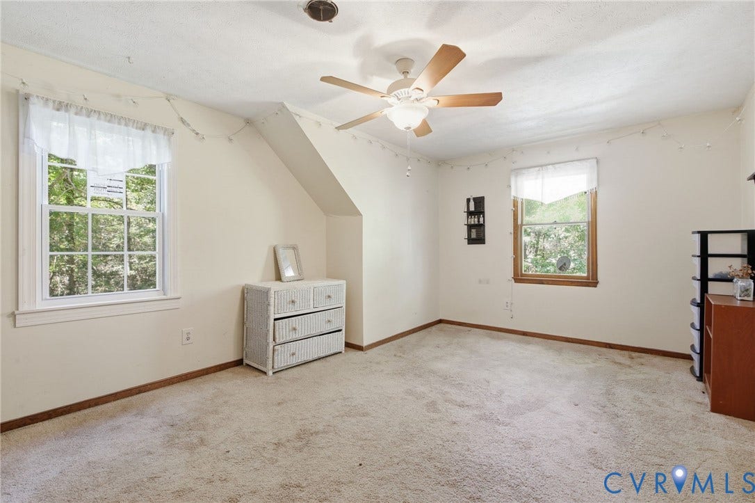 1330 Ruffin Mill Road, South Chesterfield, VA 23834 Room featuring neutral wall-to-wall carpeting, two double-hung windows with wood trim, and a ceiling fan with integrated lighting