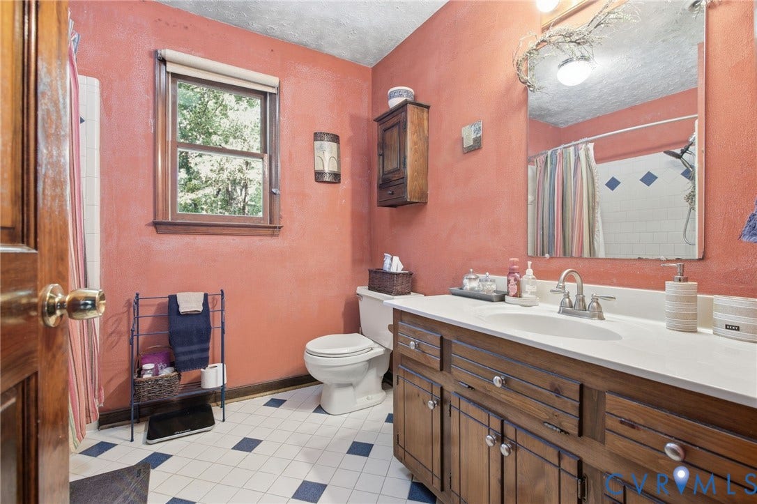 1330 Ruffin Mill Road, South Chesterfield, VA 23834 Bathroom featuring a solid wood vanity with integrated countertop, large wall-mounted mirror, ceramic tile flooring, and wood-framed window