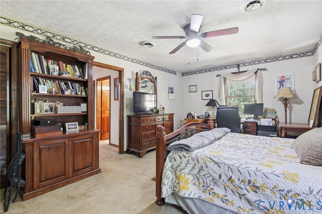 1330 Ruffin Mill Road, South Chesterfield, VA 23834 Built-in wooden shelving unit, ceiling fan with light fixture, and window with textile valance