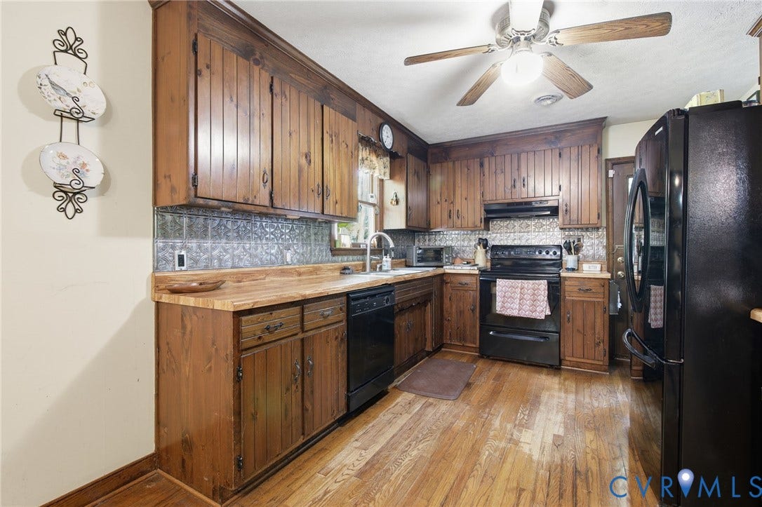 1330 Ruffin Mill Road, South Chesterfield, VA 23834 Kitchen featuring custom wood cabinetry, a decorative metallic tile backsplash, butcher block countertops, black appliances, and wood flooring