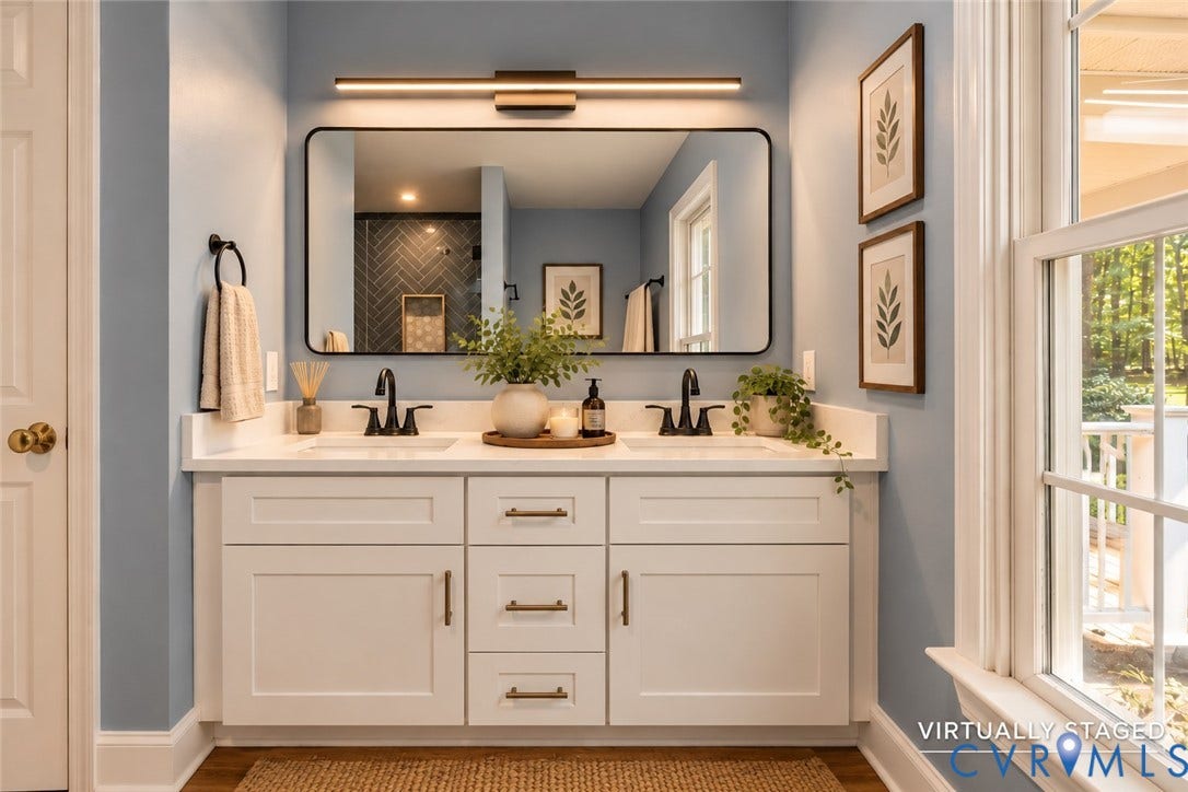 4350 Steger Creek Drive, Powhatan, VA 23139 Double vanity featuring white shaker-style cabinetry, solid-surface countertop with dual integrated sinks, matte black widespread faucets, and a large rectangular mirror with a matching matte black frame