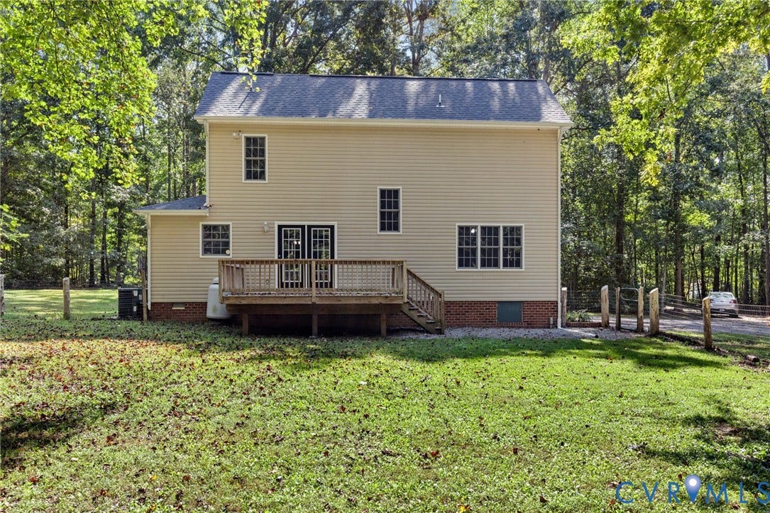 4350 Steger Creek Drive, Powhatan, VA 23139 Exterior featuring beige vinyl siding, a rear wooden deck with stairs, a brick foundation base, and multiple multi-pane windows