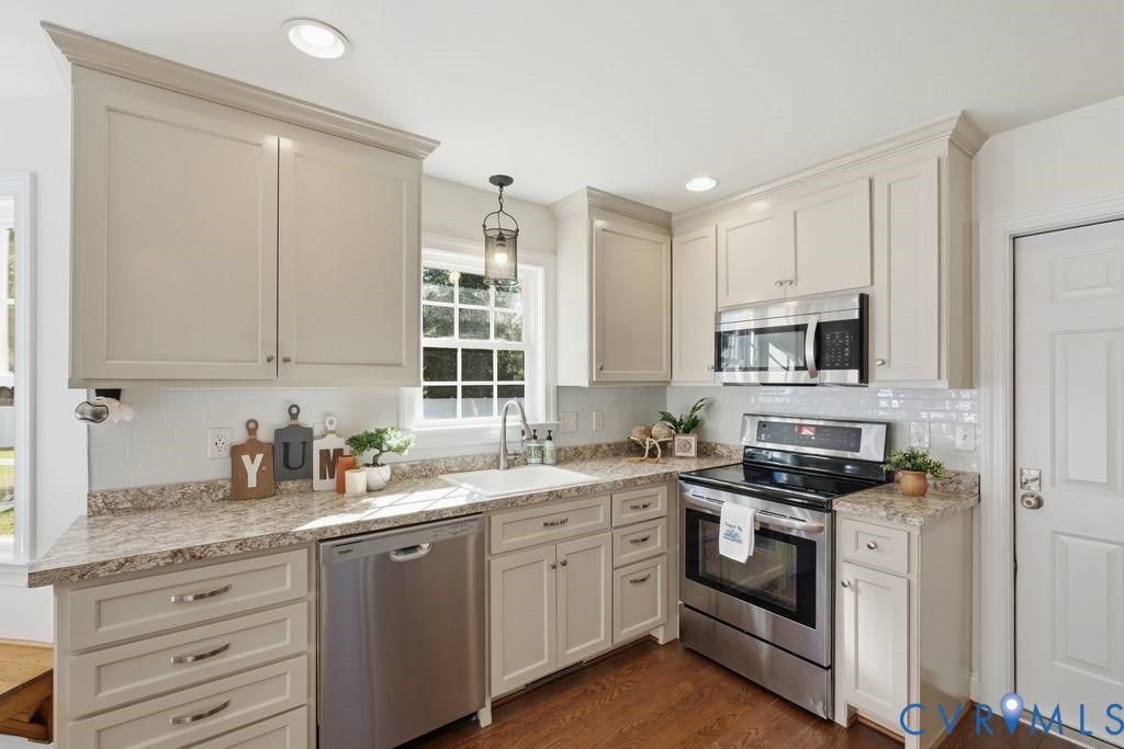 8477 Cheraw Road, Mechanicsville, VA 23116 Kitchen featuring shaker-style cabinetry, patterned stone-look countertops, stainless steel appliances, white subway tile backsplash, and wood-finish flooring