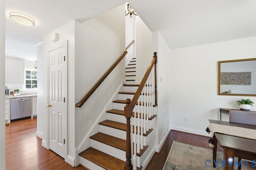 8477 Cheraw Road, Mechanicsville, VA 23116 Staircase featuring wood-finish treads, white risers, and a wooden handrail with a decorative newel post