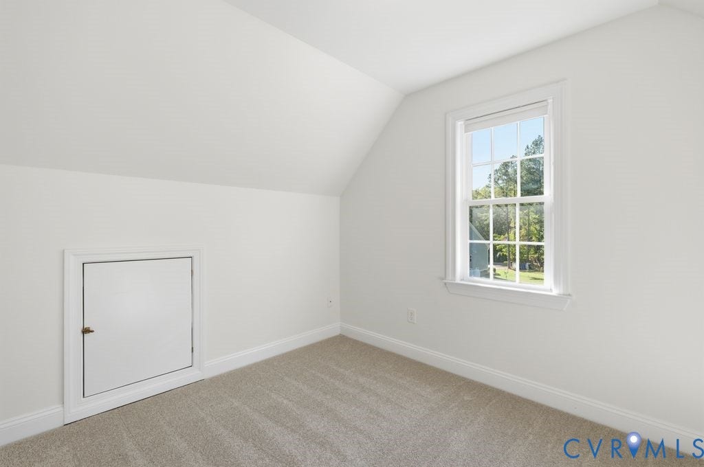 8477 Cheraw Road, Mechanicsville, VA 23116 Room featuring neutral-toned carpeting, slanted ceilings, a single-hung window with a grille pattern, and a built-in access panel