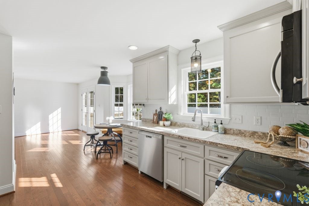 8477 Cheraw Road, Mechanicsville, VA 23116 Kitchen featuring shaker-style cabinetry, stone-finish countertops, stainless steel appliances, wood-finish flooring, and a subway tile backsplash