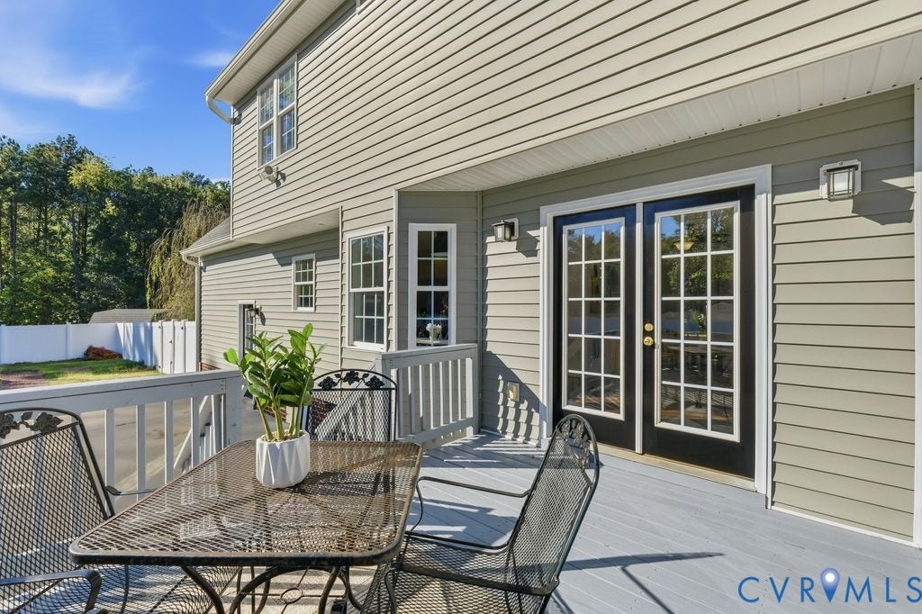 8477 Cheraw Road, Mechanicsville, VA 23116 Light-grey elevated deck featuring a white railing and black-framed French doors with glass panes