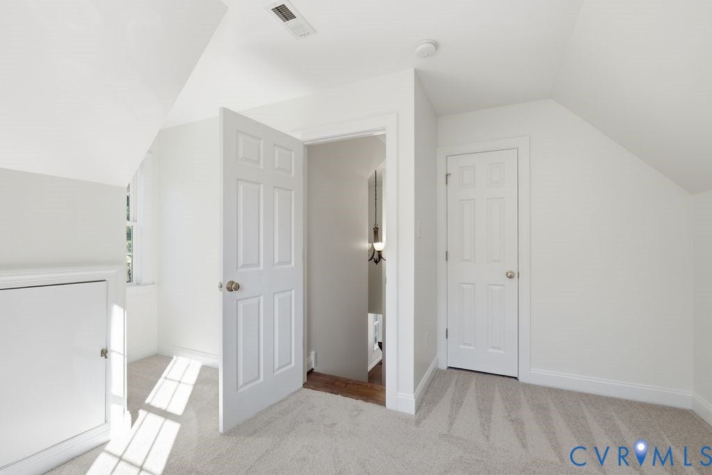 8477 Cheraw Road, Mechanicsville, VA 23116 Room with neutral carpeting, vaulted ceilings, six-panel interior doors, and built-in knee-wall storage