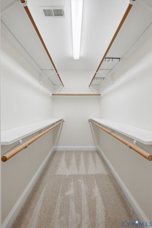 8477 Cheraw Road, Mechanicsville, VA 23116 Walk-in closet featuring multi-level hanging rods, built-in shelving, linear overhead lighting, and wall-to-wall carpeting
