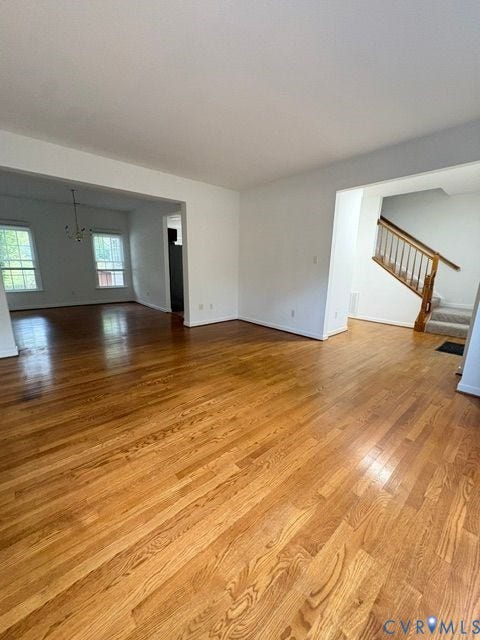 9504 Hungary Woods Drive, Glen Allen, VA 23060 Open-concept interior featuring wood-finish flooring, staircase with wood handrails, and multi-pane windows