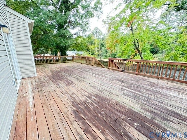 9504 Hungary Woods Drive, Glen Allen, VA 23060 Expansive elevated wood deck featuring perimeter railings and stairs leading to the grounds