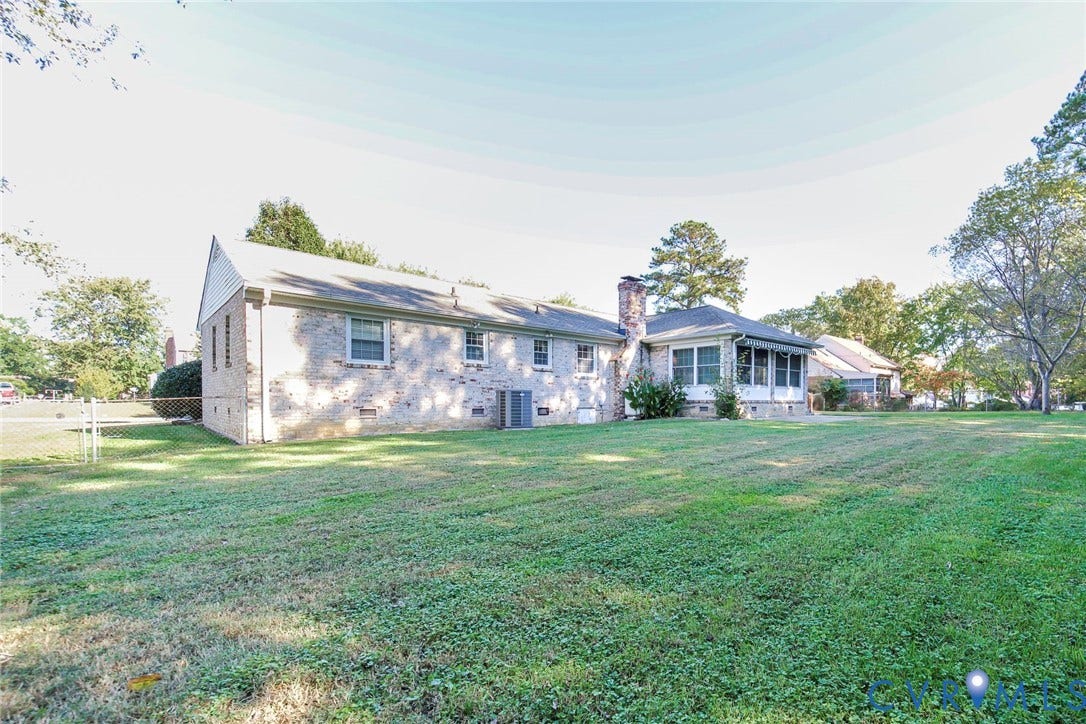 4511 Inca Drive, Ampthill, VA 23237 Brick exterior featuring a multi-gabled roofline, brick chimney, screen-enclosed patio, and an expansive lawn