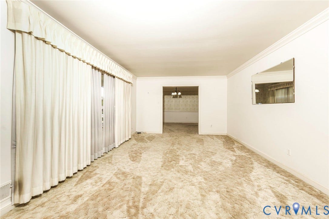 4511 Inca Drive, Ampthill, VA 23237 Spacious room featuring floor-to-ceiling drapery, neutral carpeting, crown molding, and a mounted wall mirror