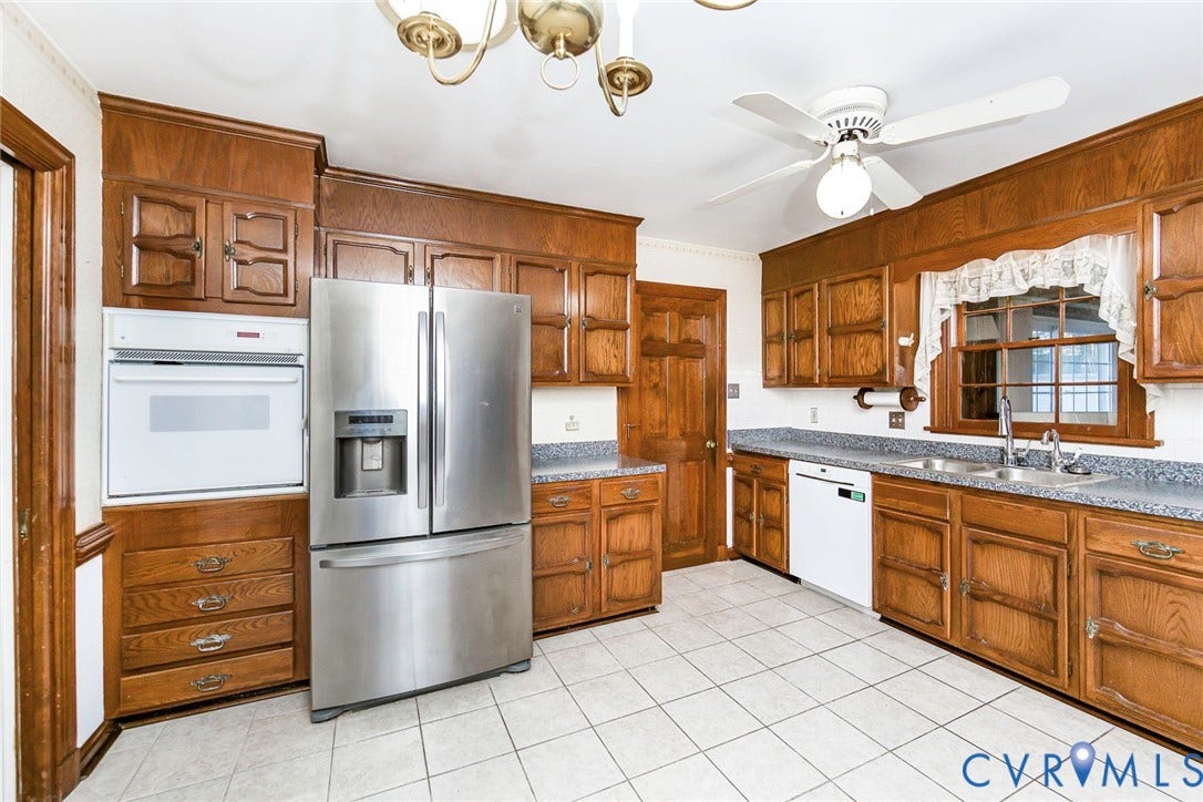 4511 Inca Drive, Ampthill, VA 23237 Kitchen featuring raised-panel oak cabinetry, speckled stone-composite countertops, stainless steel refrigerator, built-in wall oven, and ceramic tile flooring