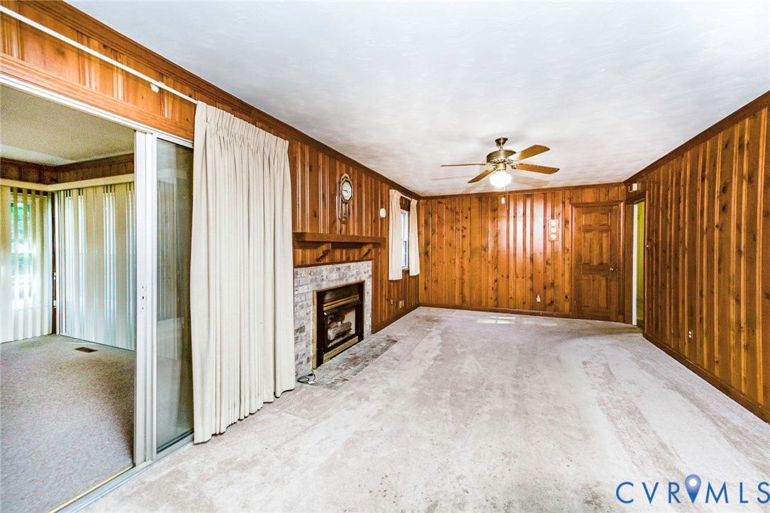 4511 Inca Drive, Ampthill, VA 23237 Wood-paneled walls, brick fireplace with a wood mantel, sliding glass door, and a ceiling fan with integrated lighting