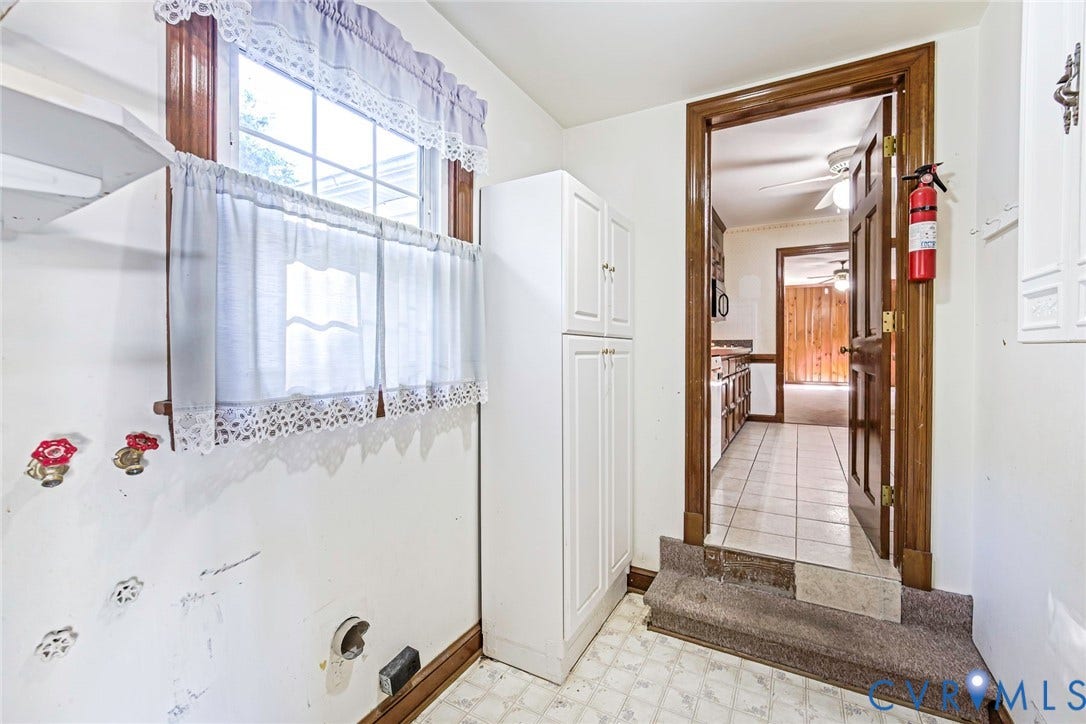 4511 Inca Drive, Ampthill, VA 23237 Utility area featuring built-in white cabinetry, multi-pane window with wood trim, and tile flooring