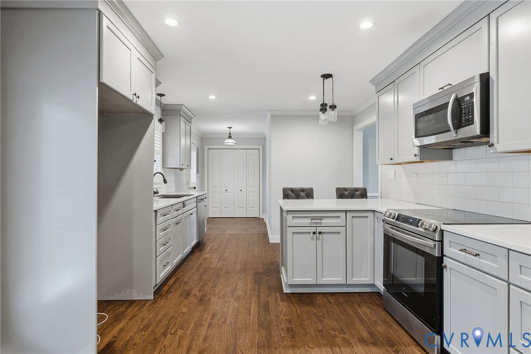 2137 Scarlet Mill Lane, Powhatan, VA 23139 Kitchen featuring shaker-style cabinetry, quartz countertops, subway tile backsplash, stainless steel appliances, and wood-finish flooring