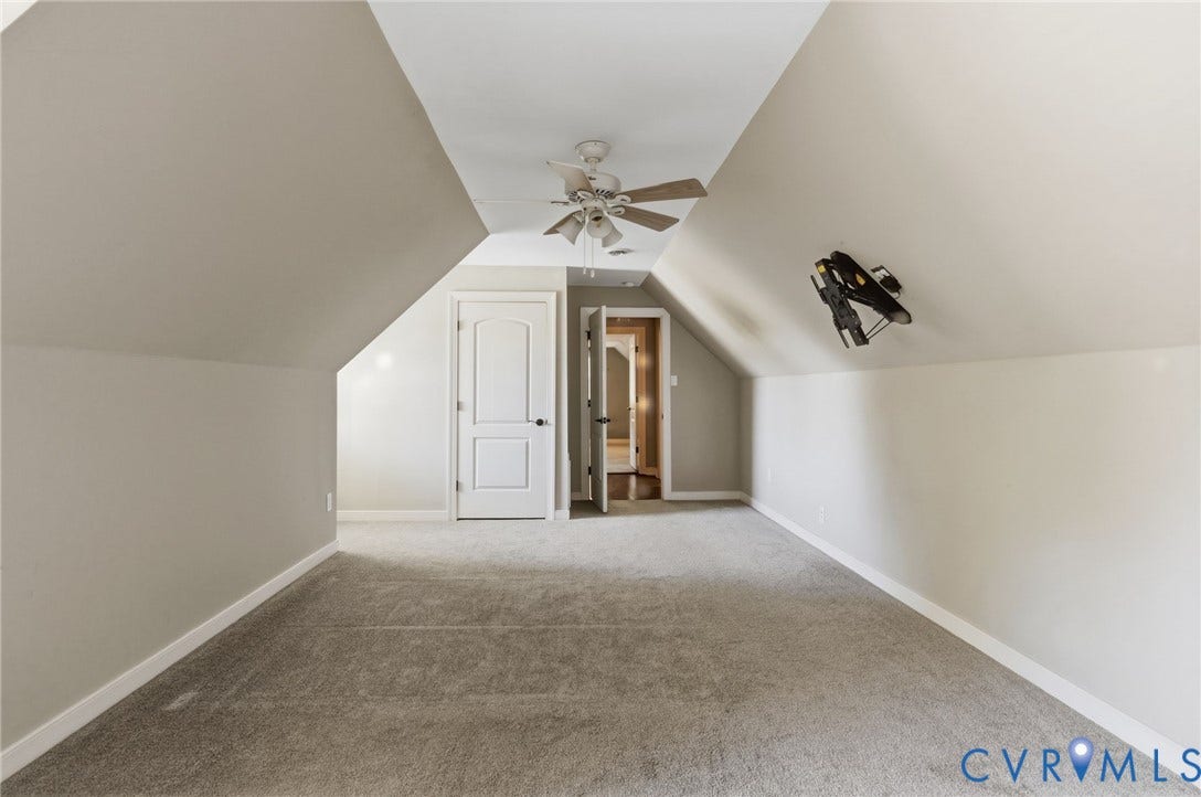 2137 Scarlet Mill Lane, Powhatan, VA 23139 Vaulted ceiling featuring a central white ceiling fan with integrated lighting, wall-to-wall carpeting, and a multi-panel interior door