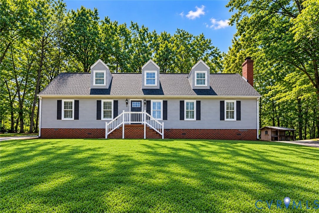 2137 Scarlet Mill Lane, Powhatan, VA 23139 Cape Cod-style residence featuring horizontal siding, a red brick base, three roof dormers, and a masonry chimney