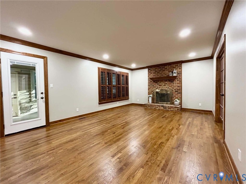 2255 Oak Bay Lane, Henrico, VA 23233 Interior space featuring wood-finish flooring, a brick fireplace with a wood mantel, crown molding, plantation shutters, and recessed lighting