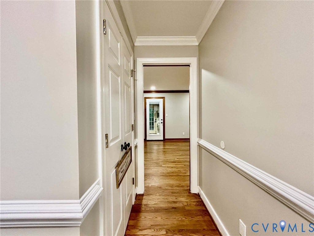 2255 Oak Bay Lane, Henrico, VA 23233 Interior hallway featuring wood-finish flooring, crown molding, chair rail trim, and a double-door closet