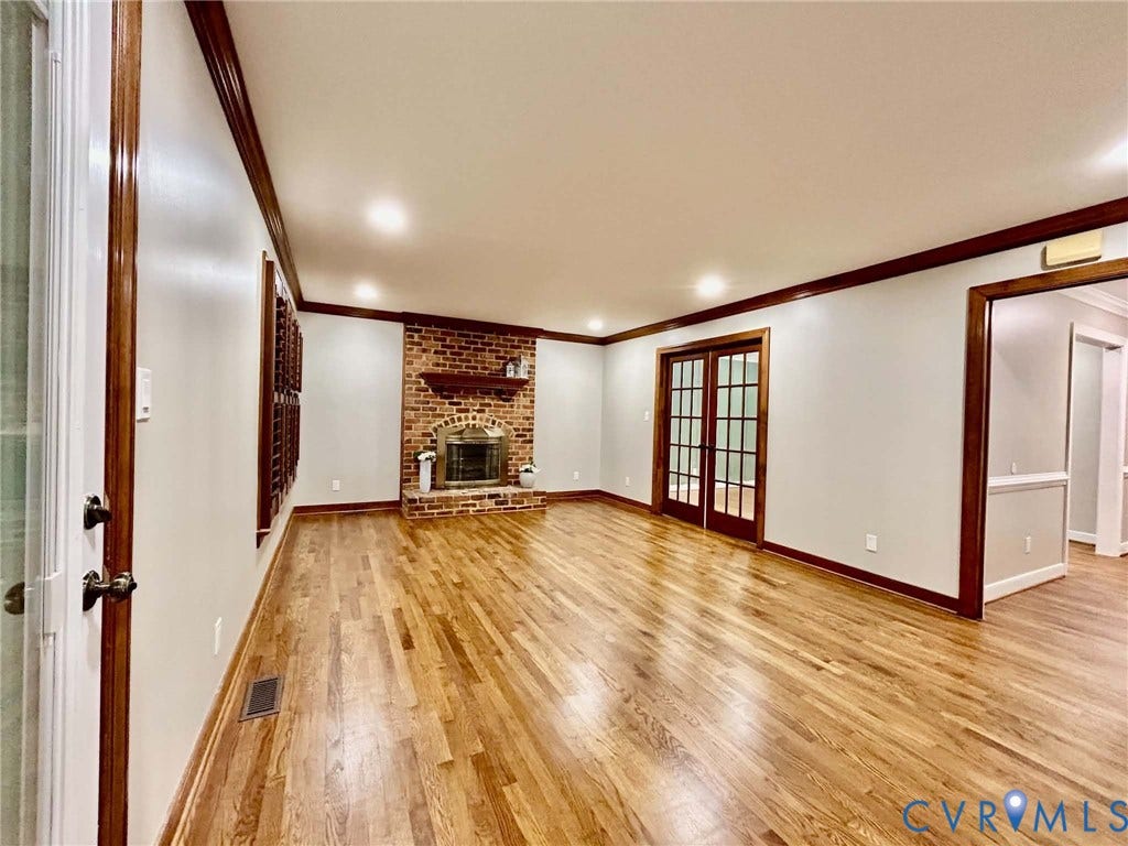 2255 Oak Bay Lane, Henrico, VA 23233 Wood-finish flooring, brick fireplace with a wood mantel, recessed lighting, and glass-paned French doors with stained wood trim