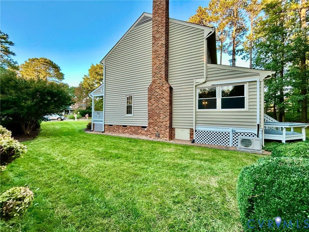 2255 Oak Bay Lane, Henrico, VA 23233 Exterior siding with a prominent full-height brick chimney, lattice foundation screening, and a side wooden deck