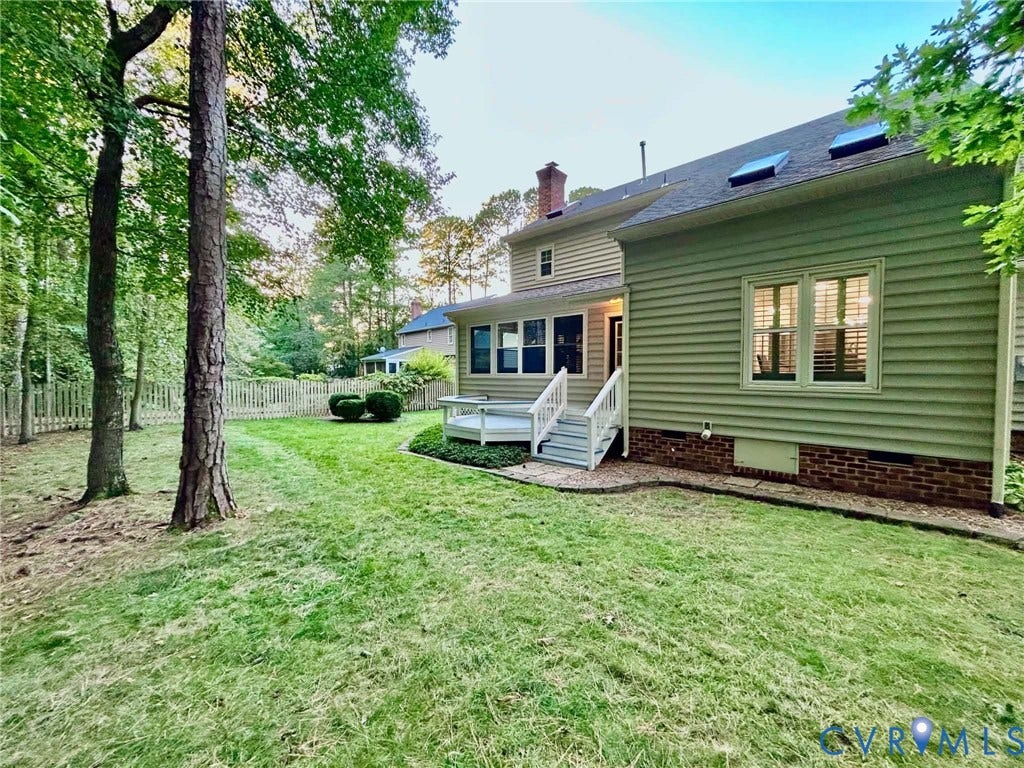 2255 Oak Bay Lane, Henrico, VA 23233 Exterior featuring lap siding, brick foundation, elevated wood deck with railing, skylights, and a fenced rear yard with mature trees