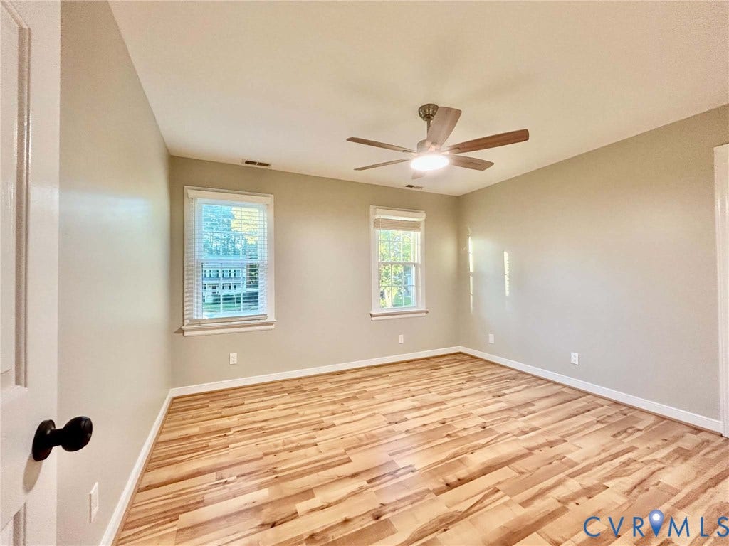 2255 Oak Bay Lane, Henrico, VA 23233 Room featuring wood-finish flooring, neutral wall paint, two double-hung windows with integrated blinds, and a central ceiling fan with an integrated light fixture
