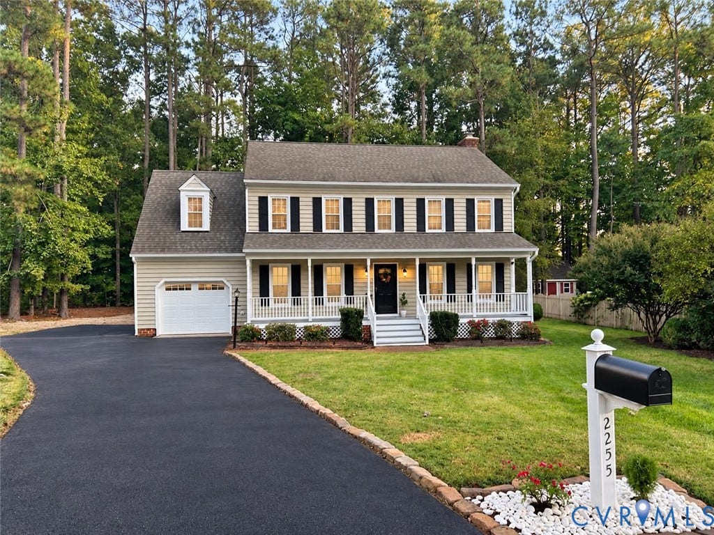 2255 Oak Bay Lane, Henrico, VA 23233 Two-story Colonial exterior featuring light-toned siding, a covered front porch with white railing, an attached garage, and an asphalt driveway
