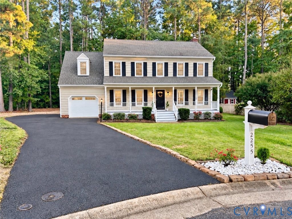 2255 Oak Bay Lane, Henrico, VA 23233 Two-story exterior featuring light-toned horizontal siding, a covered front porch with railing, a paved driveway, and established tree-lined landscaping