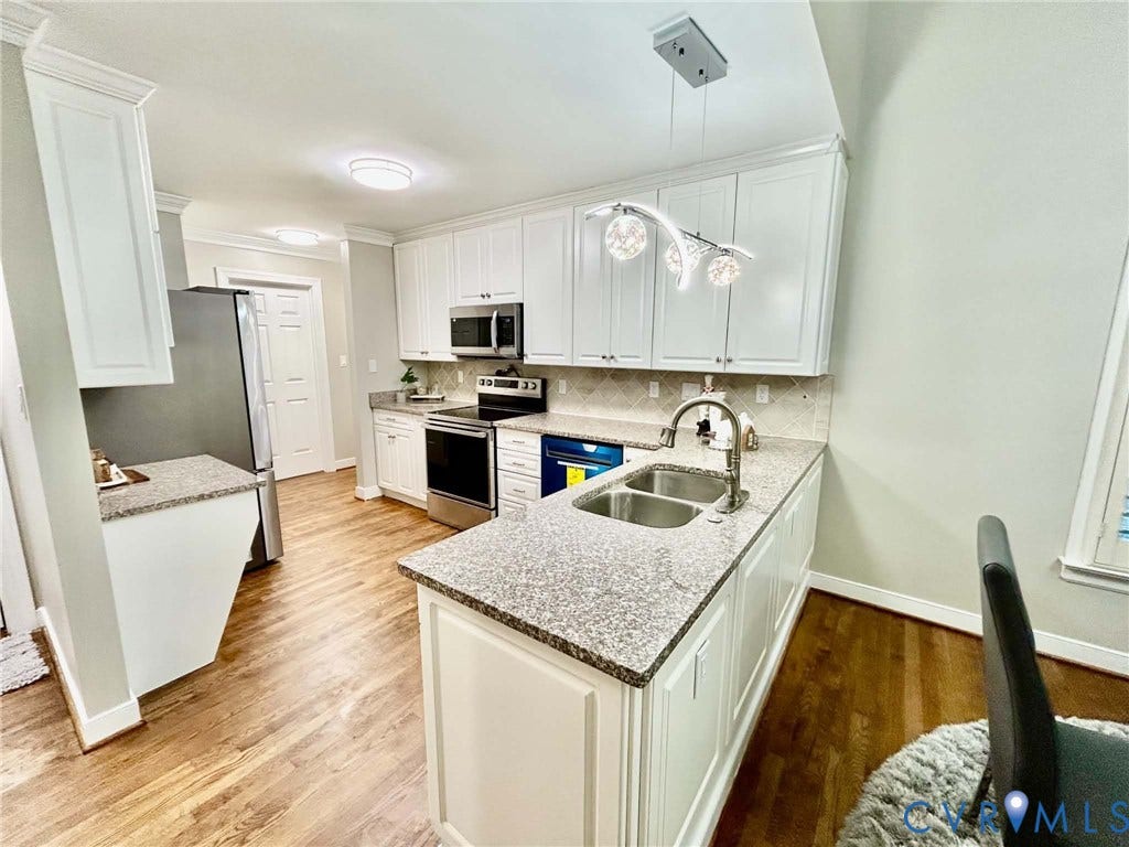 2255 Oak Bay Lane, Henrico, VA 23233 Kitchen featuring white shaker-style cabinetry, stone-finish countertops, stainless steel dual-basin sink, wood-finish flooring, and crown molding
