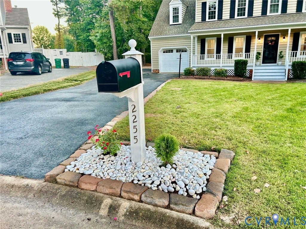 2255 Oak Bay Lane, Henrico, VA 23233 Colonial-style exterior featuring a covered front porch, asphalt driveway, and a decorative mailbox island with stone hardscaping