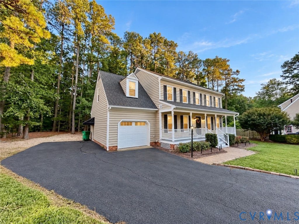 2255 Oak Bay Lane, Henrico, VA 23233 Two-story exterior featuring light-toned horizontal siding, a covered front porch with white railing, a dormer window, and an attached garage