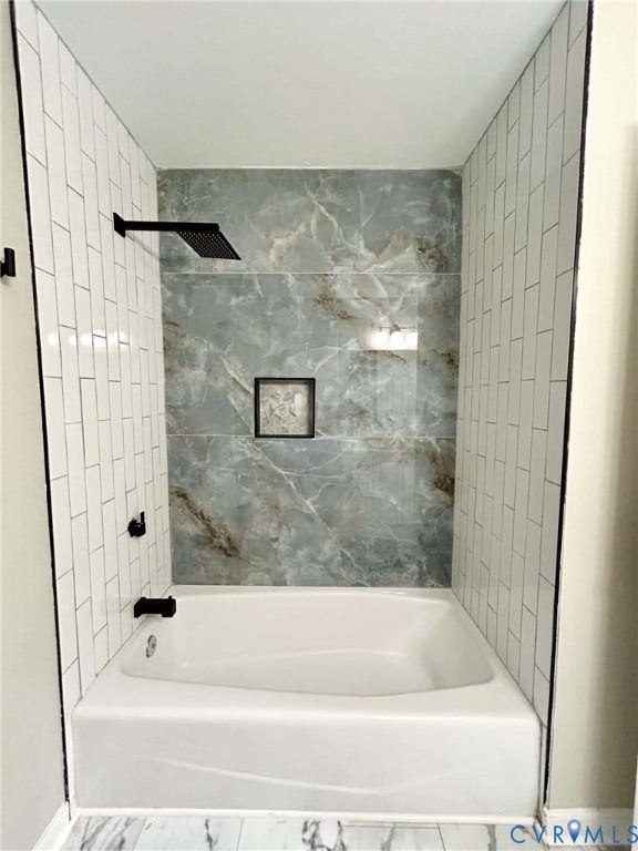 2255 Oak Bay Lane, Henrico, VA 23233 Alcove bathtub featuring white subway tile side walls, a large-format veined accent wall, a built-in recessed niche, and matte black plumbing fixtures