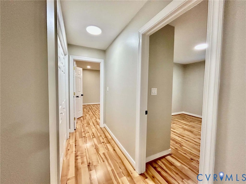 2255 Oak Bay Lane, Henrico, VA 23233 Hallway featuring wood-finish flooring, flush-mount ceiling lighting, and white door frames with matching panel doors