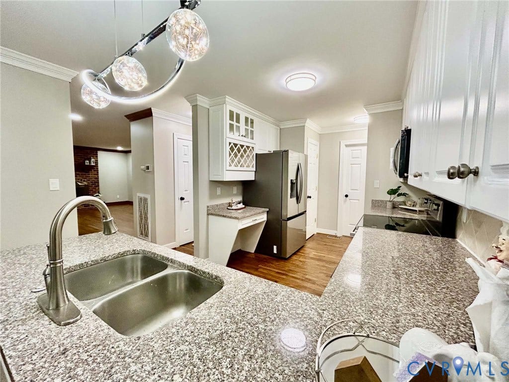 2255 Oak Bay Lane, Henrico, VA 23233 Kitchen featuring speckled stone countertops, dual-basin stainless steel sink with arch faucet, white cabinetry with built-in wine rack, wood-finish flooring, and contemporary multi-pendant lighting