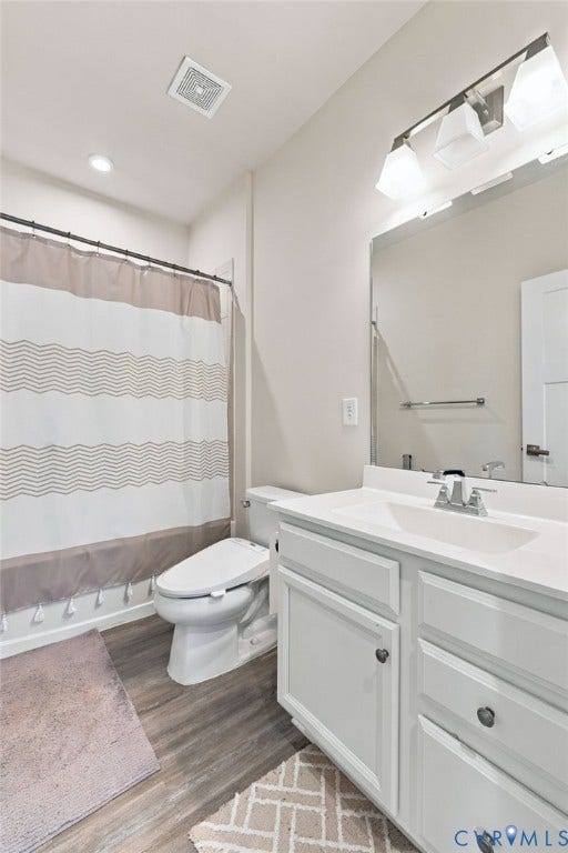 1716 German School Road, Westlake Heights, Richmond, VA 23225 Bathroom featuring a white vanity with integrated basin, multi-light fixture, large wall mirror, wood-finish flooring, and a tub-shower combination