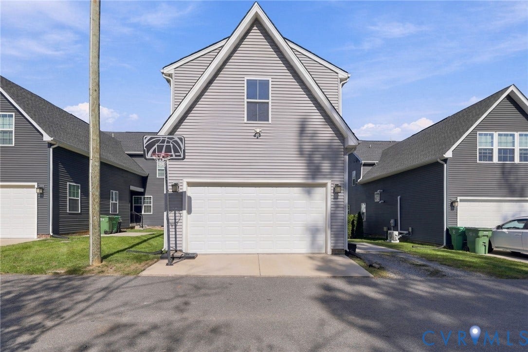 1716 German School Road, Westlake Heights, Richmond, VA 23225 Two-story exterior featuring light gray horizontal siding, a gabled roofline, concrete driveway, and white sectional garage door